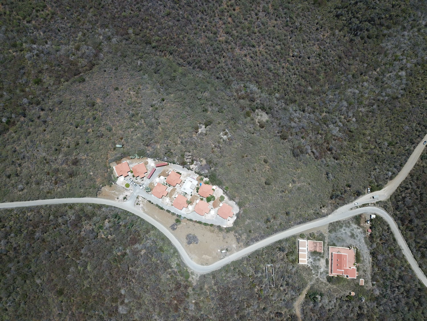 Het resort recht van boven, acht daken rond het centrale zwembad